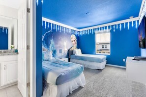 Un dormitorio con dos camas, un ventanal grande y un mural de un personaje.
