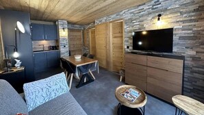 Un espace de vie compact comprenant une cuisine, un coin repas et un coin salon.