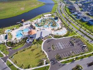 An aerial view of a resort with a large swimming pool, a parking lot, and a body of water. - Disney! Private Pool, Game Room & Themed Bedrooms. Book Now! #SLR493 (Orlando)