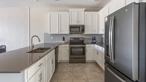 Una cocina moderna con armarios blancos, electrodomésticos de acero inoxidable y una isla grande.
