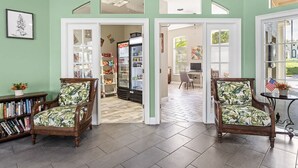 A spacious living room with two wooden chairs, a bookshelf, and a refrigerator. - Disney Getaway! Townhouse with Private Pool. Book Now! #EIR68 (Orlando)