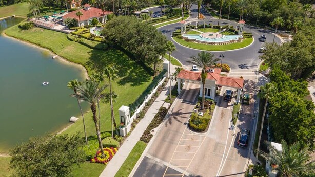 An aerial view of a resort with a central road, a swimming pool, and a lake. - Disney Getaway! Townhouse with Private Pool. Book Now! #EIR68 (Orlando)