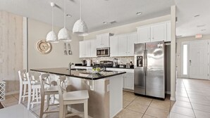 A modern kitchen with white cabinetry, stainless steel appliances, and pendant lighting. - Disney Getaway! Private Pool & Themed Bedrooms. Book Now! #Solt429 (Orlando)