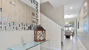 A modern interior with a glass console table, a decorative lantern, and a patterned wall. - Disney Getaway! Private Pool & Themed Bedrooms. Book Now! #SLR506 (Orlando)