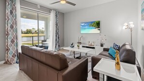 Ein modernes Wohnzimmer mit Sofa, Couchtisch und einem Gemälde einer Strandansicht.
