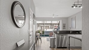 Ett modernt kök med en central köksö, rostfria vitvaror och en matplats med bord och stolar.