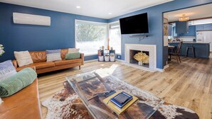 A living room with a sofa, a coffee table, and a fireplace. - The Nest with Firepit & Backyard Swings (Klamath Falls)
