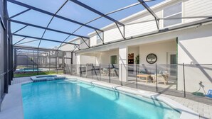 A swimming pool with a glass enclosure, a patio area with seating, and a view of the surrounding landscape. - Last Minute Disney Getaway! Private Pool, Game Room & Themed Bedrooms. Book Now! #147905 (Orlando)