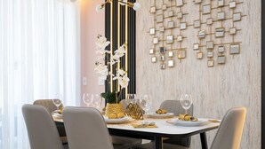 A dining area with a table set for four, featuring modern chairs, a decorative centerpiece, and a wall with a geometric mirror design. - Last Minute Disney! Private Pool & Themed Bedrooms. Book Now! #SLR516 (Orlando)