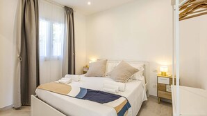 Une chambre à coucher bien rangée, avec un lit, des tables de chevet et une petite table de nuit.