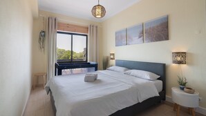 Una camera da letto con un letto, una finestra, un comodino con una lampada e decorazioni alle pareti.