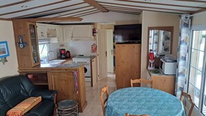 A compact living space with a kitchenette, a dining area, and a sofa.