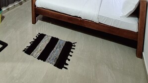 Um quarto com teto de madeira, uma cama, uma escrivaninha e uma cadeira.