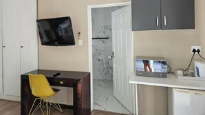 A modern room with a desk, a television, and a microwave.