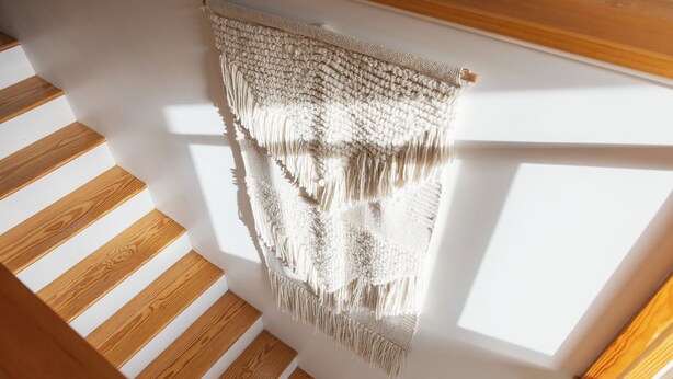 A staircase with wooden steps and a hanging woven textile.