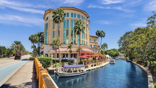 A hotel with a canal view, a boat dock, and outdoor seating.