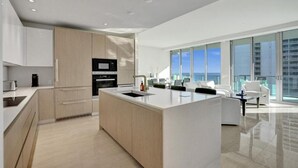 Una cocina moderna con una isla central, electrodomésticos integrados y vistas a la ciudad.