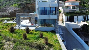 A modern two-story house with a stone facade, large windows, and a balcony. - Theasea Luxury Residence (Malevizi)