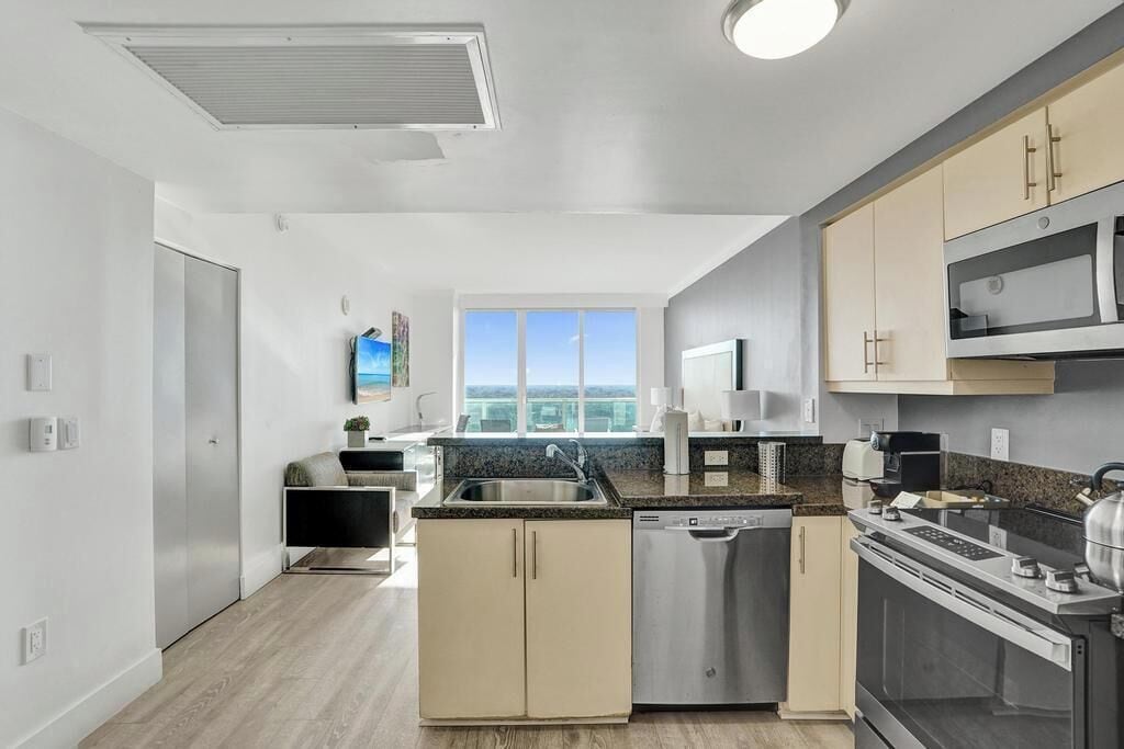A modern kitchen with a dishwasher, oven, and microwave.