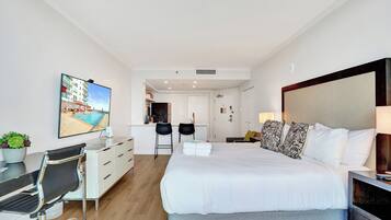 Une chambre d’hôtel avec un lit, un bureau, une chaise et un tableau au mur.