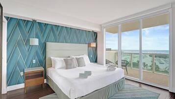 Camera da letto con un letto grande, un comodino, una lampada, vista mare e un balcone.