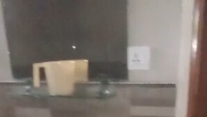 Une salle de bain avec un lavabo blanc, un miroir et une étagère en verre au-dessus du lavabo.