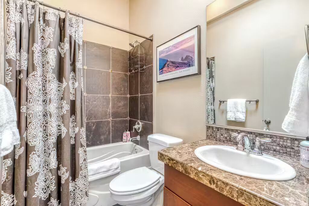 A bathroom with a shower, toilet, and sink.
