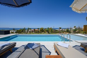 Piscine extérieure, parasols de plage, chaises longues
