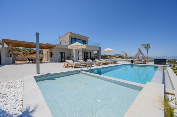 Piscine extérieure, parasols de plage, chaises longues