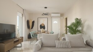 Un salon comprenant un téléviseur, un canapé et un coin repas.