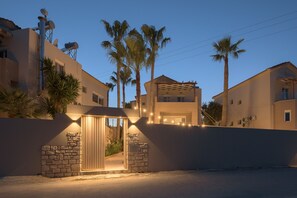 Un edificio moderno con entrada de piedra, varias ventanas y un balcón.
