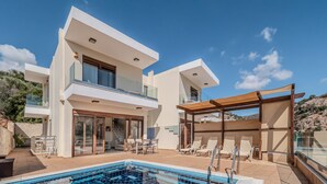 A modern two-story house with a swimming pool, outdoor seating, and a pergola. - Villa Paris (Malevizi)
