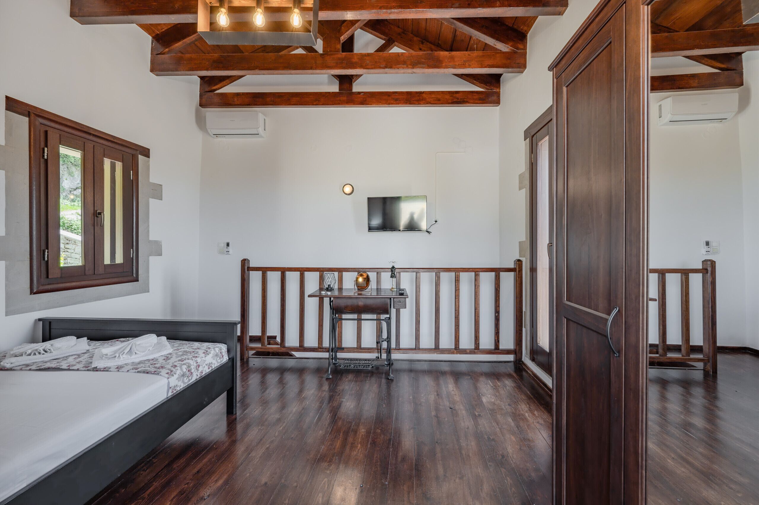 Un dormitorio con cama, escritorio, televisión y armario.
