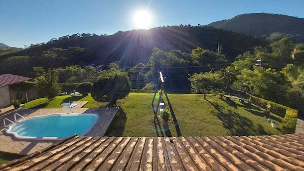 A wooden deck with a swimming pool and a garden.