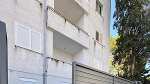 A gated entrance to a building with a paved pathway leading to a door.