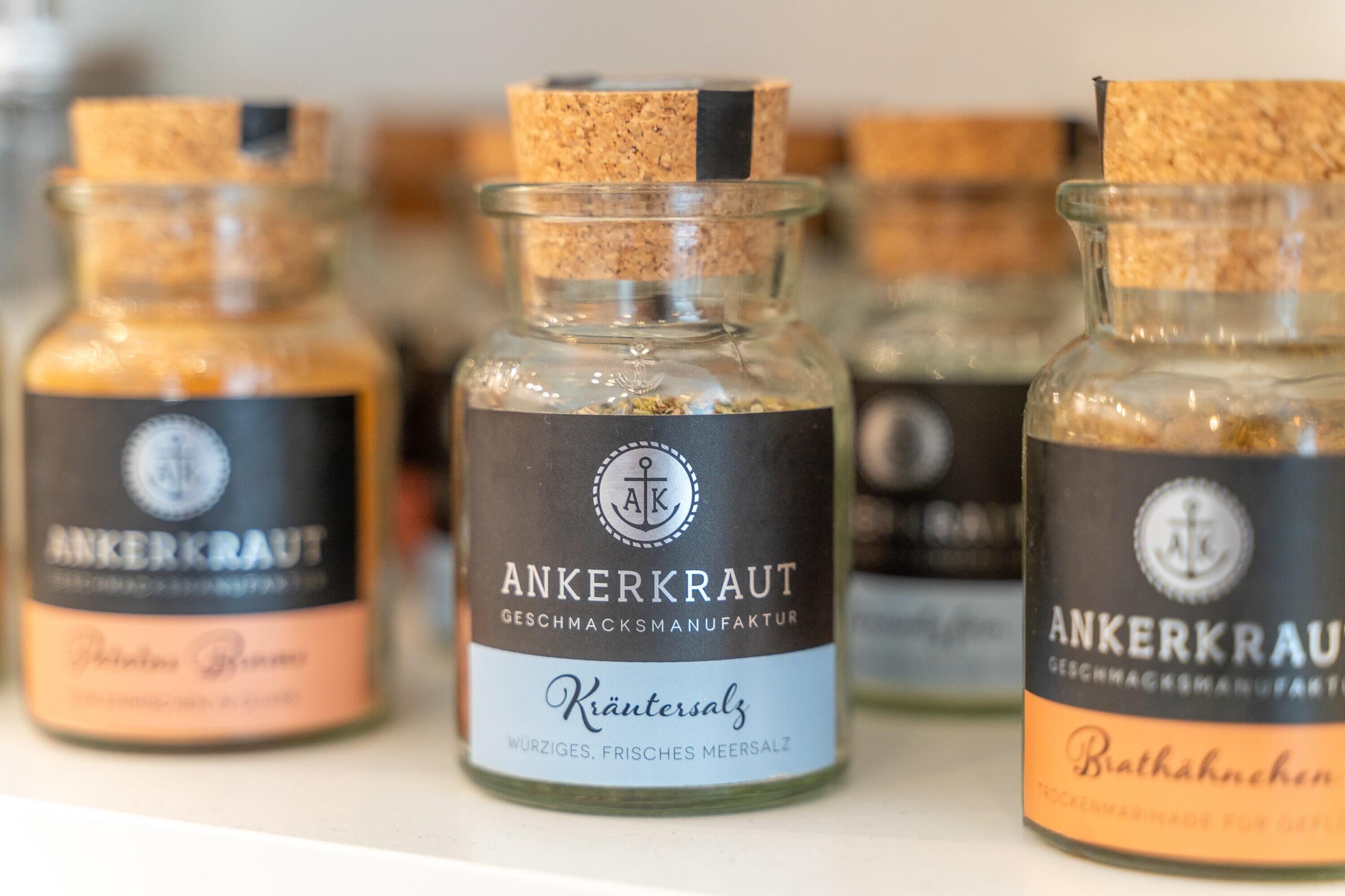 Drei Glasflaschen mit Korken, jeweils beschriftet mit 'ANKERKRAUT' und unterschiedlichen Namen wie 'Kräutersalz' und 'Brathahnen'.