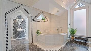 Un baño moderno con una bañera independiente, un lavamanos y una zona de ducha.
