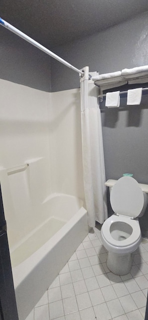 Een bad, handdoeken, shampoo, toiletpapier