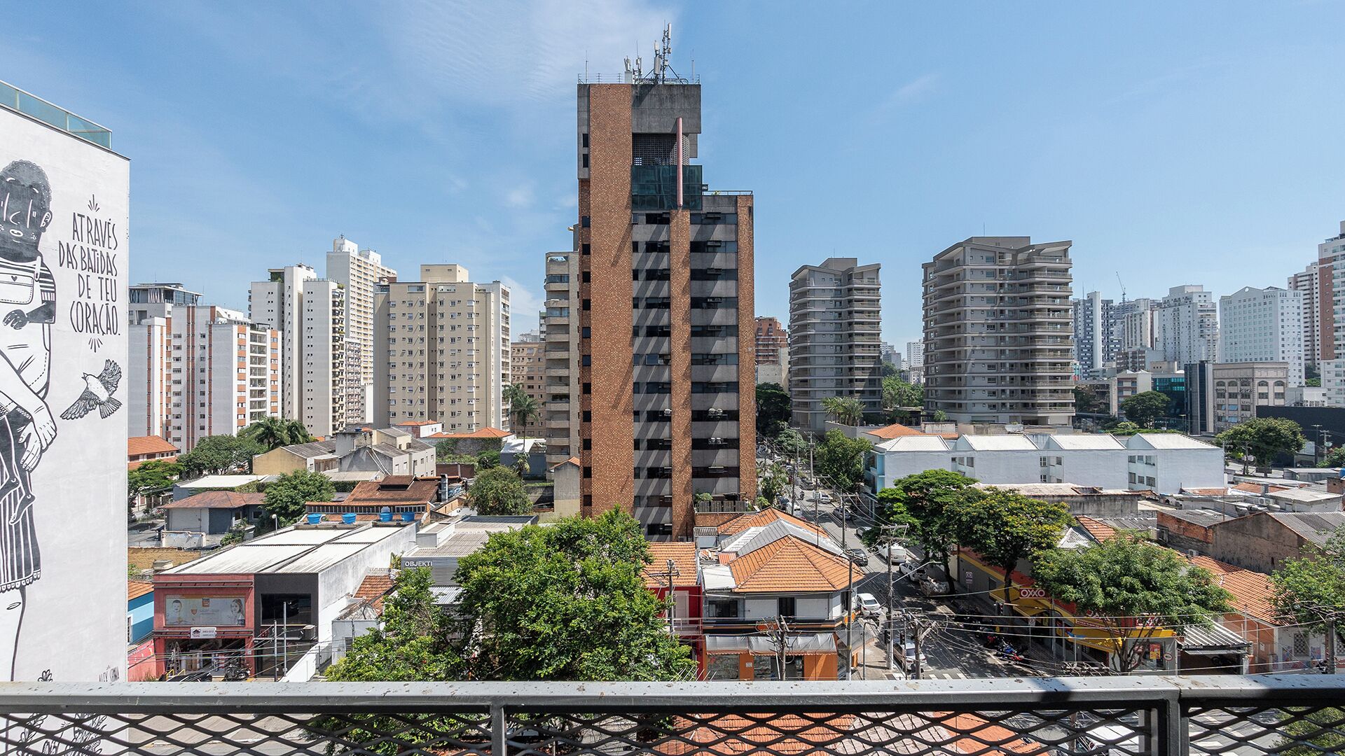A cityscape with a prominent tall building in the center, surrounded by other residential and commercial buildings.