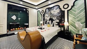 A modern hotel room with a bed, a bathroom, and a decorative wall.