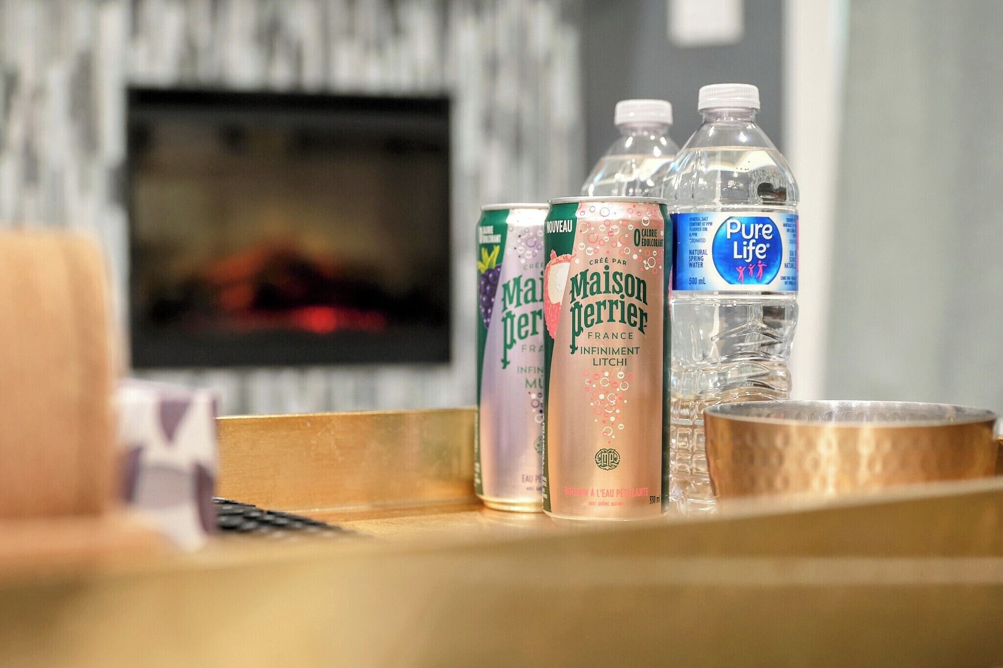 A tray with bottled water and cans of water in a hotel setting.