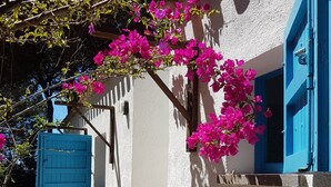 A narrow street with white walls and blue shutters, leading to a building with a door and a window. - Beachfront villa, right ON SAND! (Cala Liberotto)
