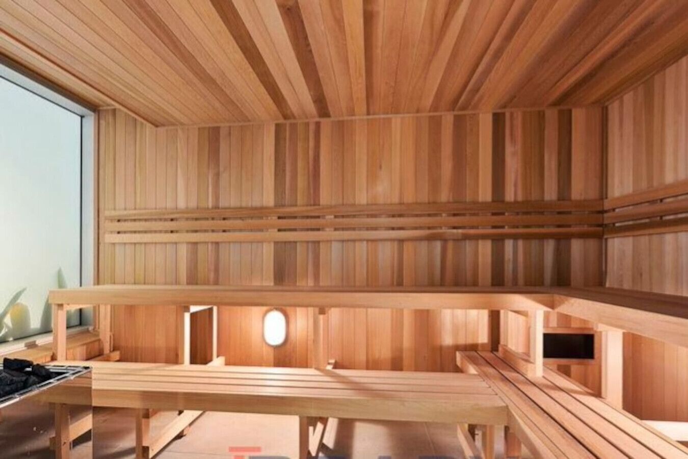 Een sauna met houten banken en een schuin dak.