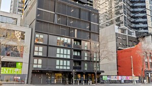 Un edificio de varios pisos con un diseño arquitectónico moderno, que cuenta con amplios ventanales y una entrada destacada.