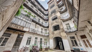 Une cour intérieure à plusieurs étages, dotée de balcons, d’un escalier et d’un support à vélos.