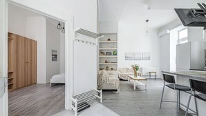 Un espace de vie moderne, à aire ouverte, comprenant une cuisine, un coin repas et un espace nuit séparé.