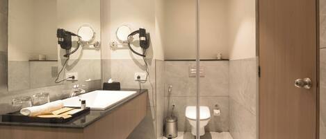 Une salle de bain moderne avec une douche à parois de verre, un meuble-lavabo et des toilettes.