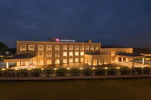 A modern hotel with a prominent sign, multiple entry points, and a well-lit exterior.
