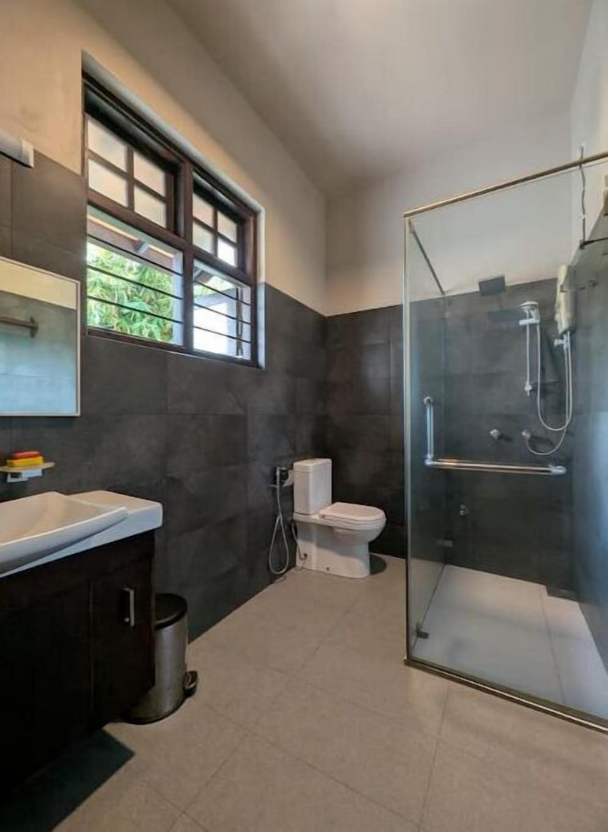Un baño moderno con ducha de vidrio, inodoro y lavamanos.