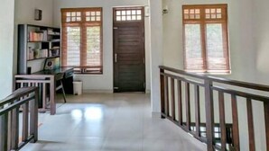 A spacious interior with a high wooden ceiling, a staircase, and a long hallway.